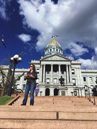 Low angle view of woman standing against sky