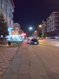 Cars on illuminated street in city at night