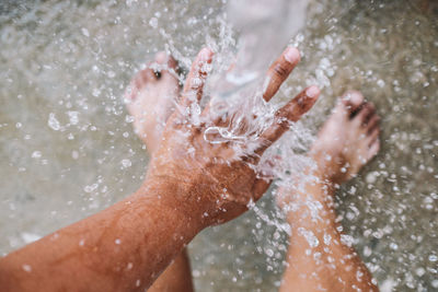 Midsection of man splashing water in bathroom