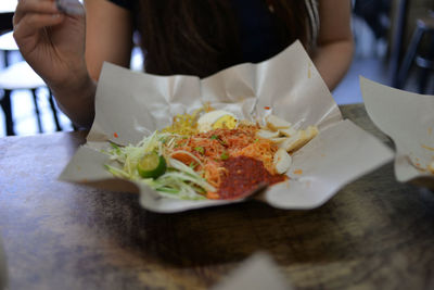 Midsection of woman holding food in restaurant