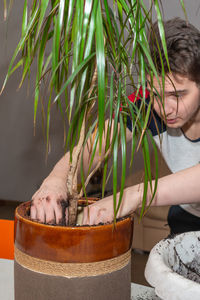 Side view of young woman with potted plant