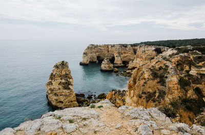 Rock formations by sea against sky