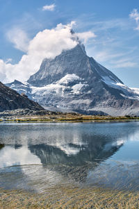 Scenic view of lake and snowcapped mountains against sky