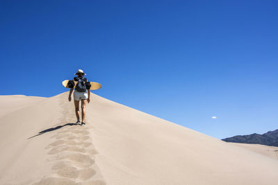 Full length of man on desert against clear sky