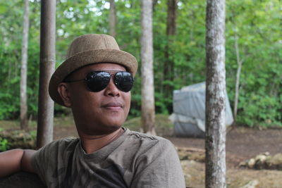 Portrait of man wearing sunglasses in forest