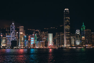 Illuminated buildings against sky at night