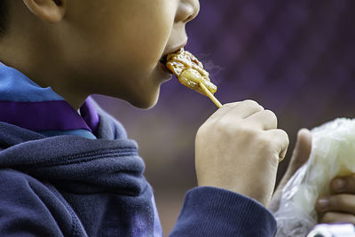 Midsection of boy eating food