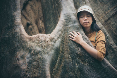 Woman embracing tree trunk