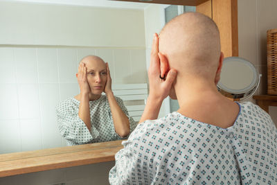 Side view of young woman looking away while sitting at home