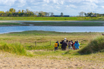 People on agricultural field against sky