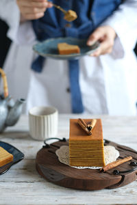 Kueh lapis, thousand layer cake in hand in frame stillife