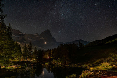 Scenic view of lake and matterhorn against sky at night