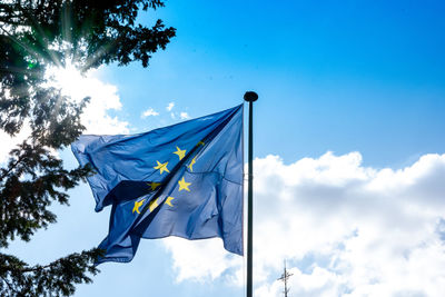 Low angle view of flag against blue sky