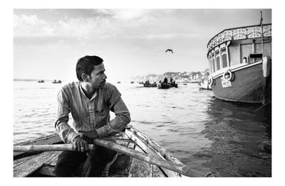 Young man on boat against sky