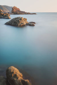 Rock formation in sea against sky