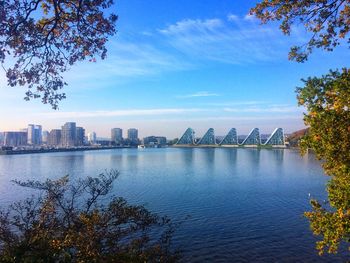 Scenic view of river by buildings against sky