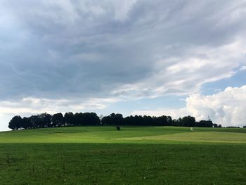 Scenic view of grassy field against cloudy sky