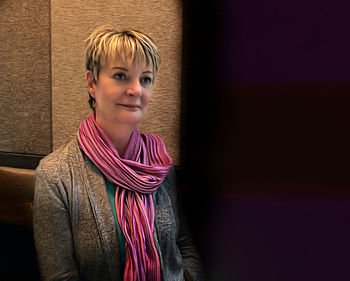 Portrait of teenage girl standing against wall