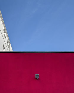 Low angle view of red building against blue sky