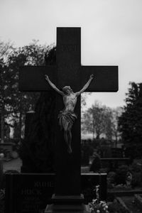 Statue in cemetery against sky