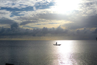 Silhouette boat in sea against sky during sunset