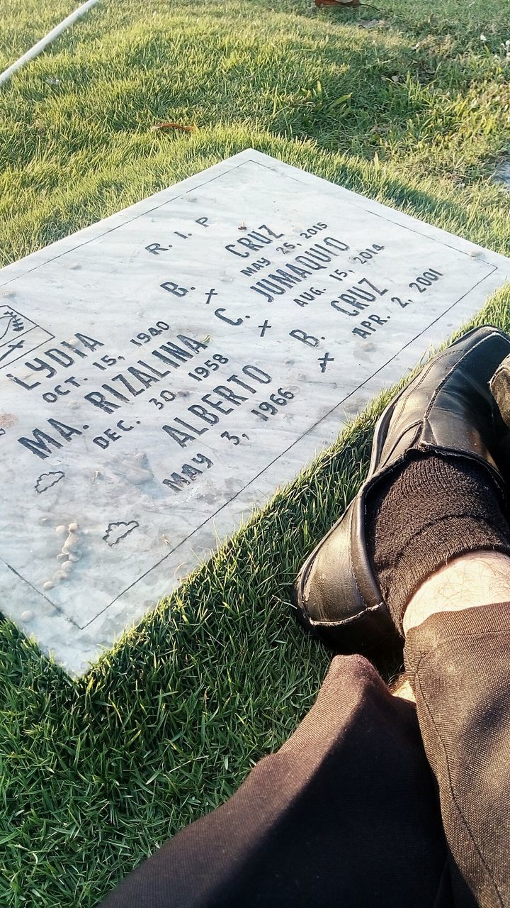 low section, person, personal perspective, grass, field, high angle view, lifestyles, leisure activity, landscape, shoe, men, unrecognizable person, sunlight, nature, outdoors, tranquility, day