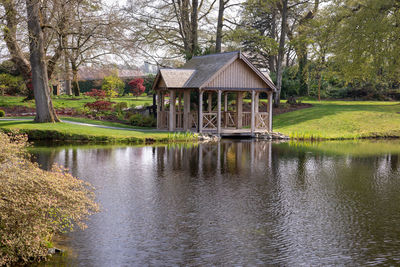 House by lake against trees