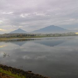 Scenic view of lake against cloudy sky