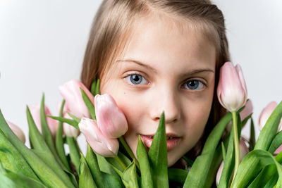 Close-up portrait of cute girl against white background