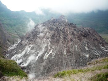 High angle view of smoke emitting from volcanic mountain