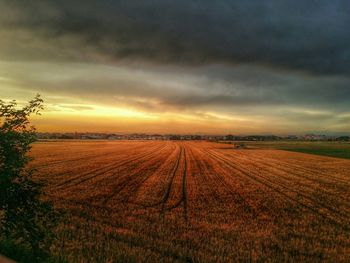 Scenic view of field against cloudy sky