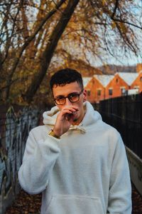 Portrait of young man smoking cigarette outdoors