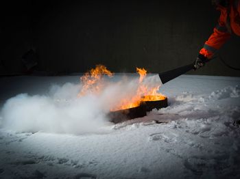 Midsection of man with fire crackers at night