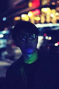Close-up portrait of smiling man in city at night