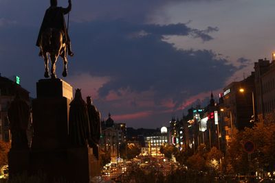 Statue in city against sky at night