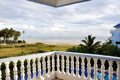 Balcony by sea against cloudy sky