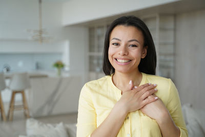 Portrait of young woman sitting at home