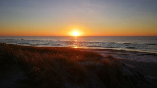 Scenic view of beach against sky during sunset