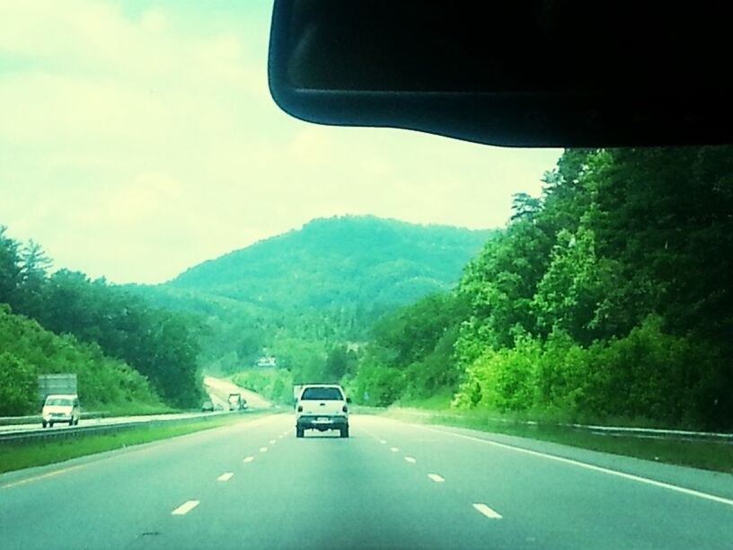 transportation, road, car, land vehicle, mode of transport, mountain, road marking, the way forward, country road, tree, sky, on the move, landscape, windshield, highway, travel, mountain range, diminishing perspective, street, car interior