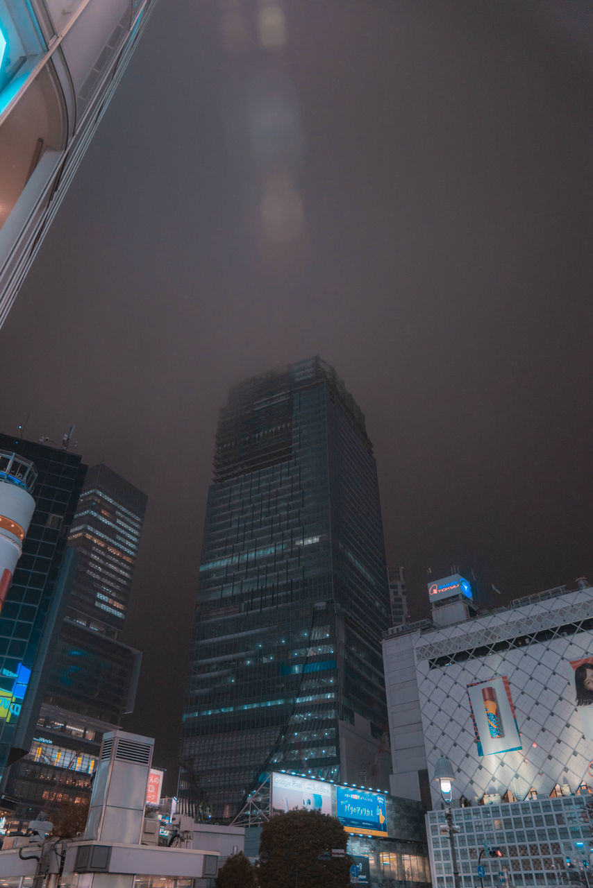 LOW ANGLE VIEW OF ILLUMINATED BUILDINGS AT NIGHT