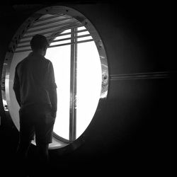 Rear view of woman standing by railing