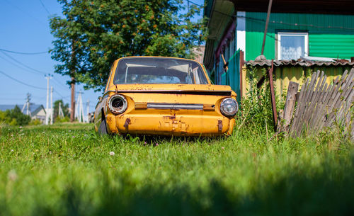 Old yellow wrecked car in vintage style. abandoned rusty yellow car. 