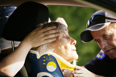 Close-up of paramedic putting neck brace on patient in car