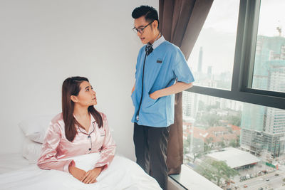 Young couple sitting on window