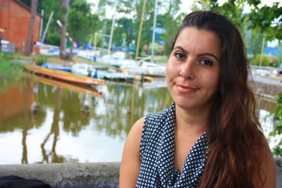 Chubby brunette caucasian girl tired frightened face in front water  lake massaciuccoli with boats