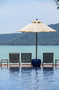 Sun loungers and parasol by the pool at holiday resort in phuket