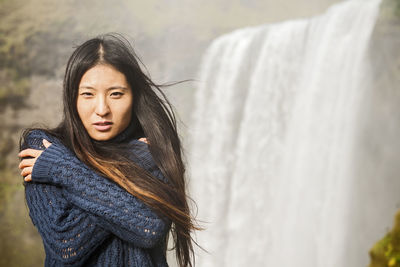 Beautiful woman posing at skogarfoss waterfall in iceland