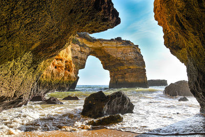 Rock formations in sea against sky