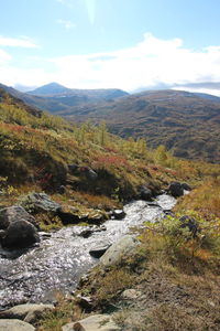 Scenic view of river amidst mountains against sky