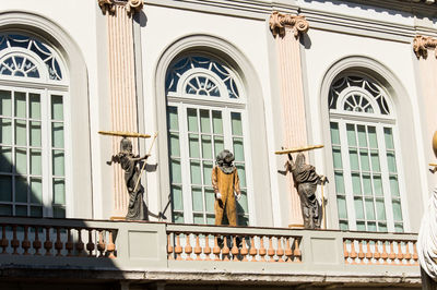 Low angle view of statue against building in city